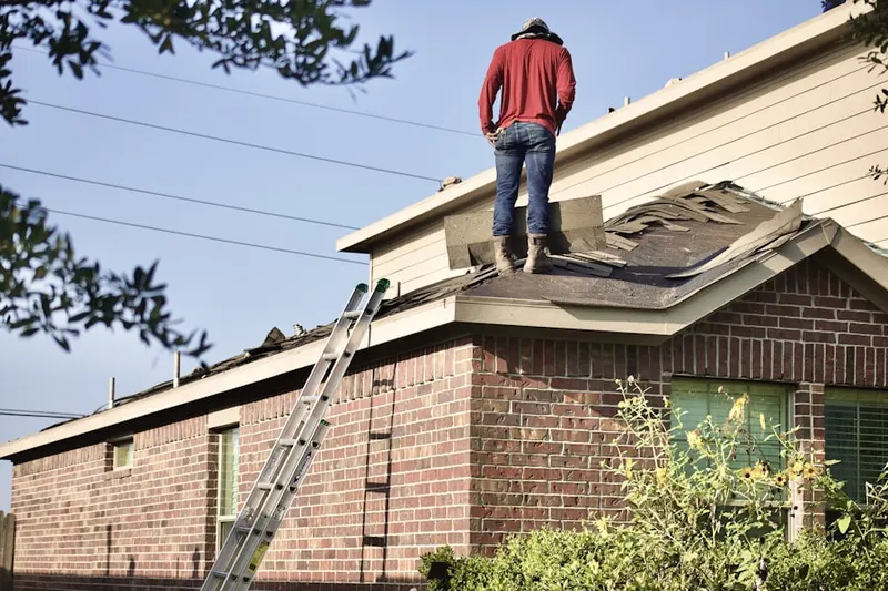 Professional roofer working on a residential roof in Creedmoor